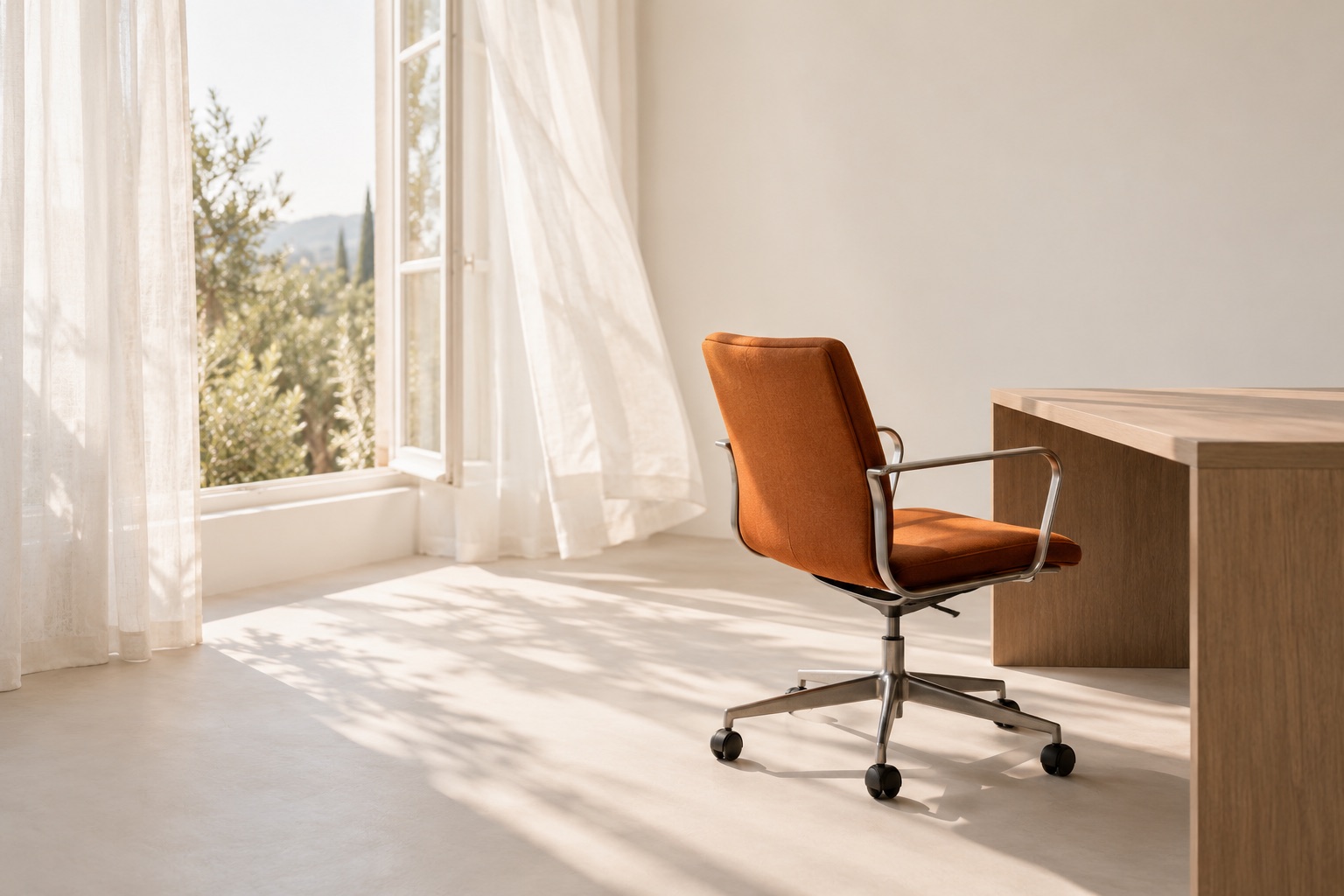 A burnt-orange desk chair sits beside a bare wooden desk and a bright open window.